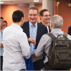 Niel Riordan, PA and PhD, talking to people at a conference